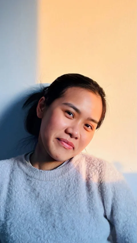 A woman smiles in soft, warm light