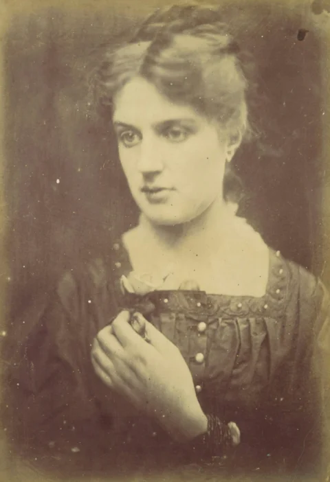 Sepia-toned portrait of a woman holding a small object
