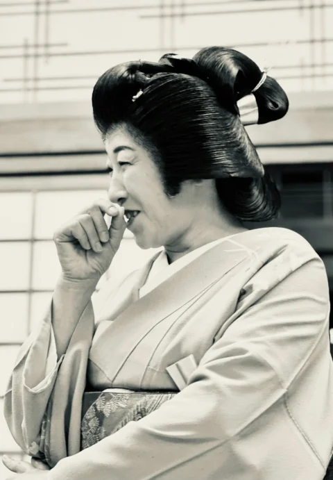 a woman in a kimono talking on a cell phone