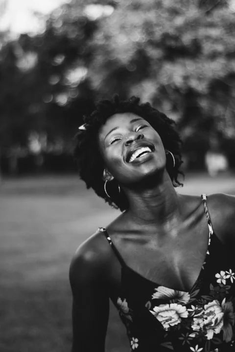 A black and white photo of a woman laughing