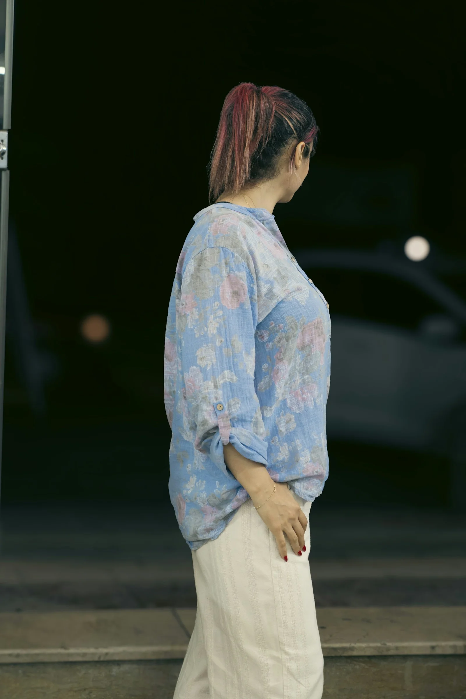 Woman in floral shirt looking away from camera