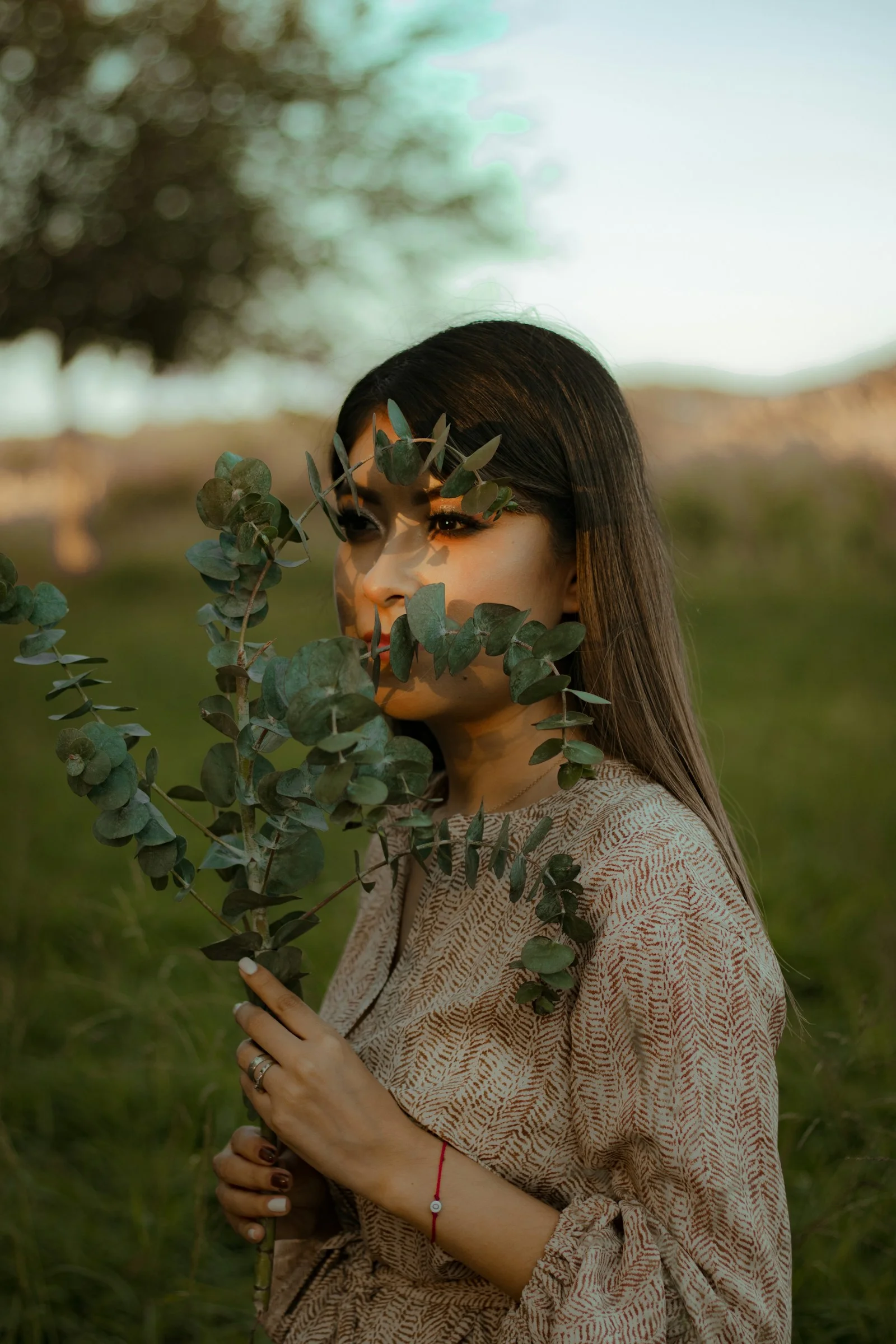 a woman standing in a field with leaves on her face