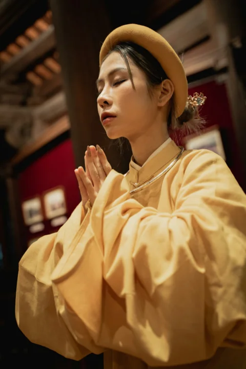 穿黃色連身裙、戴棕色帽子的女子
