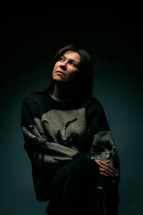 A woman sitting on a chair in a dark room
