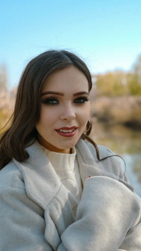 Young woman with makeup and coat outdoors