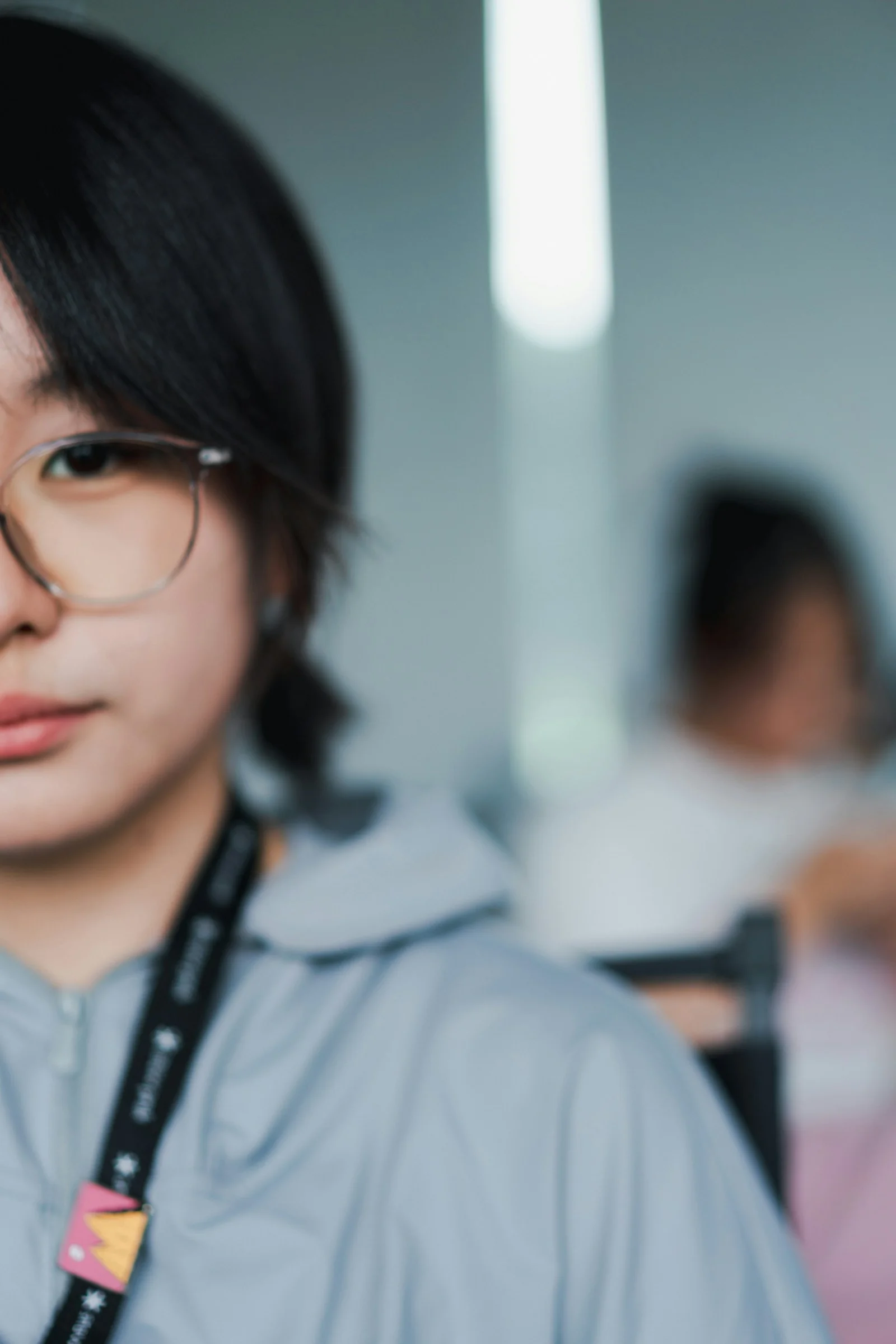 一名戴眼鏡、掛著證件掛繩的年輕女子