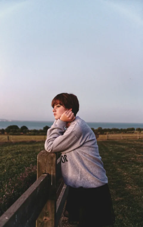 woman leaning on fence