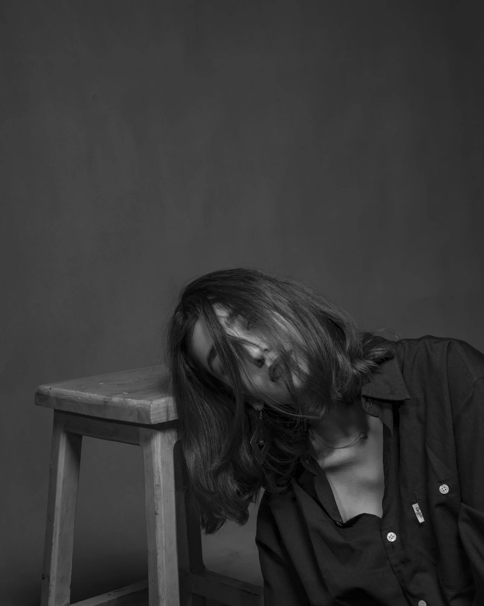 坐在椅子旁的女人的灰度照片