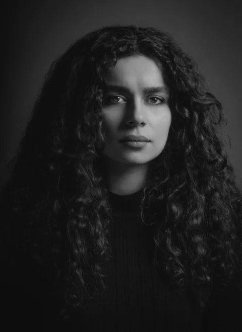 a black and white photo of a woman with curly hair