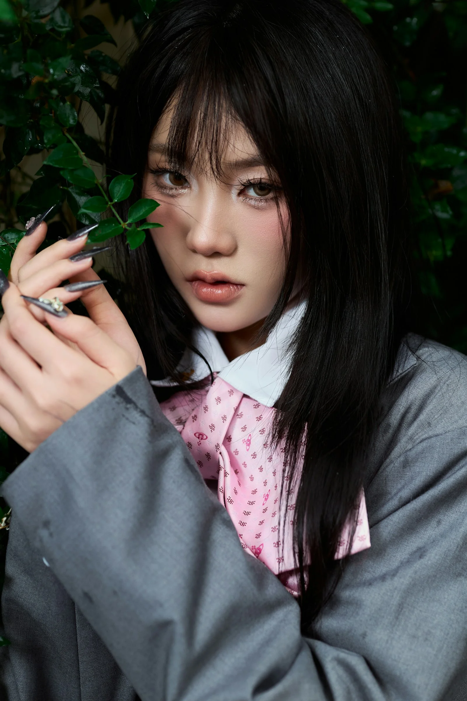 一位穿灰色夹克的年轻女人手持绿叶