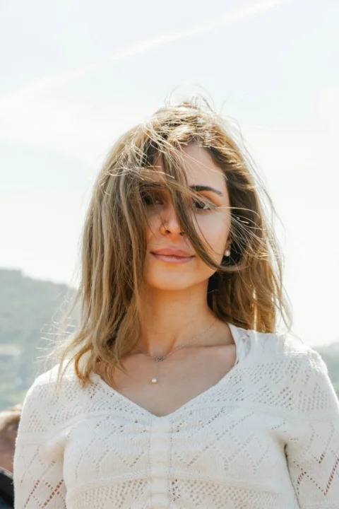 a woman with long hair standing in front of a mountain