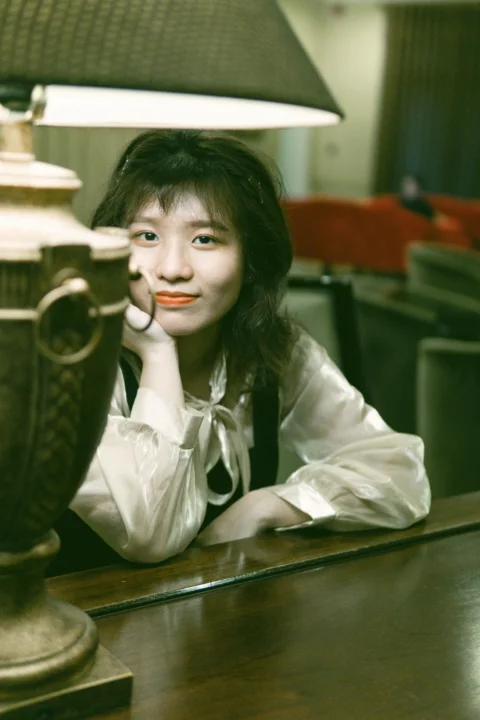 穿白色正装衬衫坐在棕色木椅上的女人