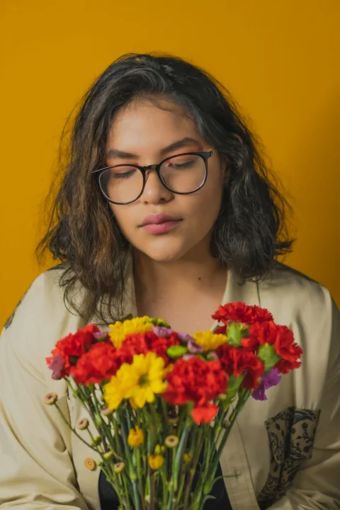 woman in white shirt holding bouquet of flowers