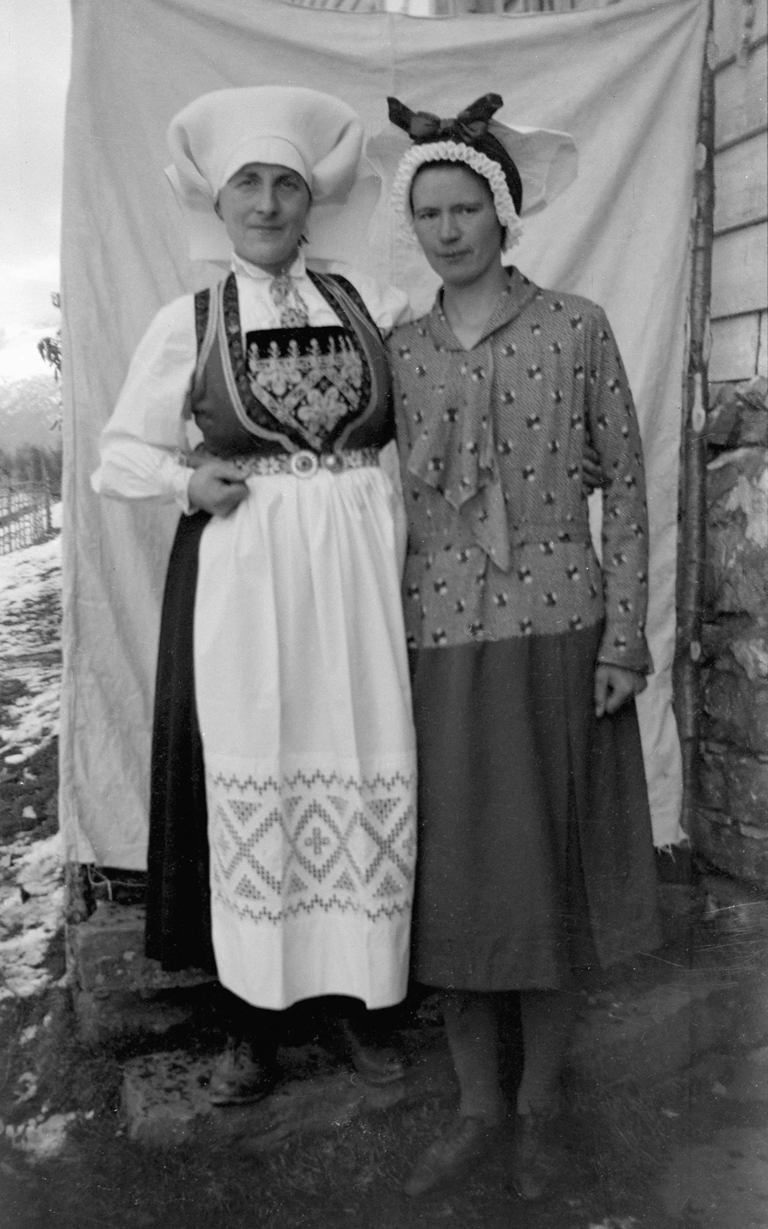 Two women in traditional folk costumes stand together