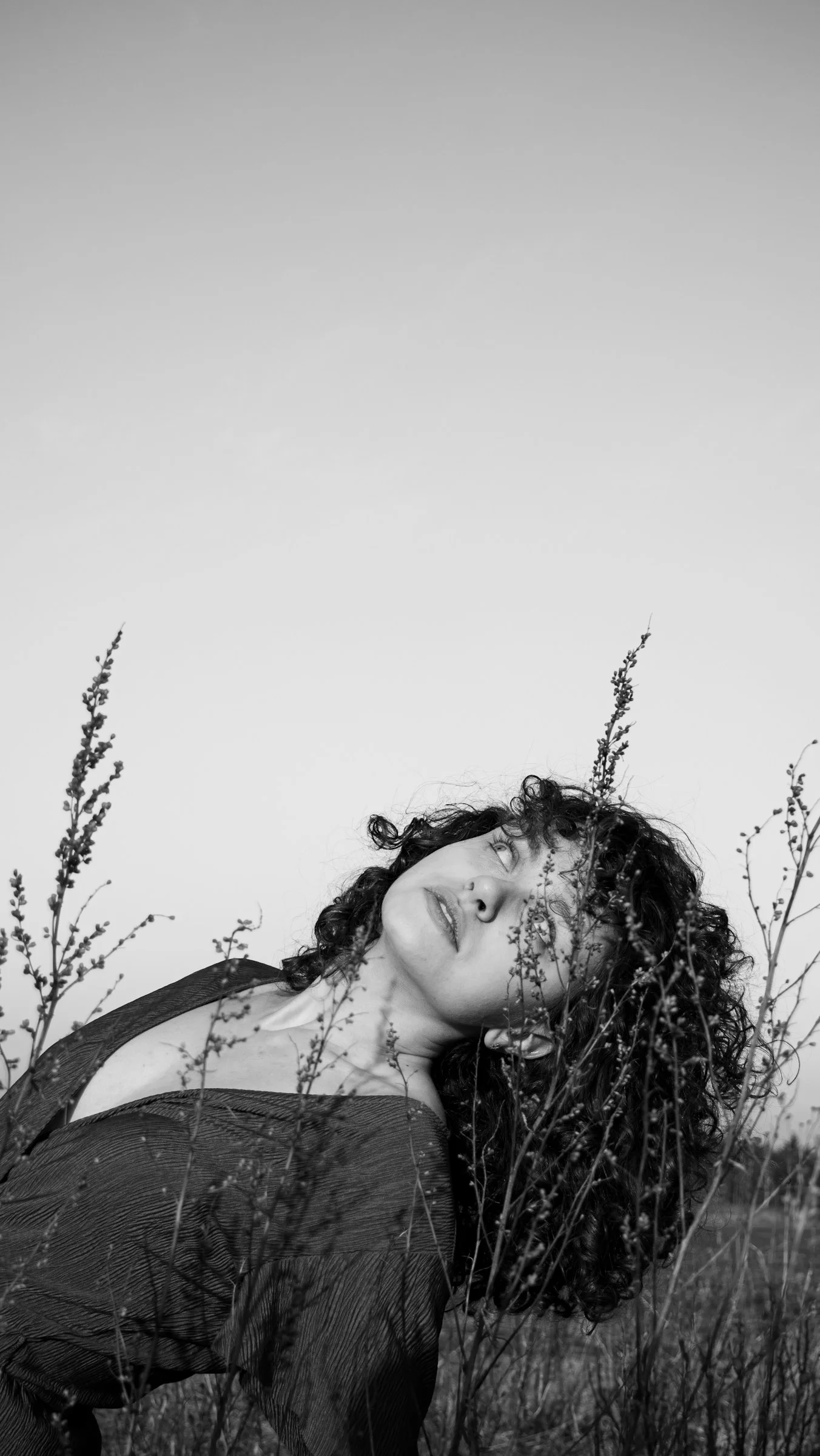 a woman is laying down in a field