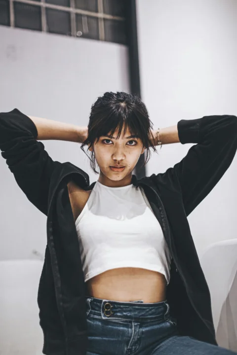 一位坐在沙发上手持棒球棒的女子
