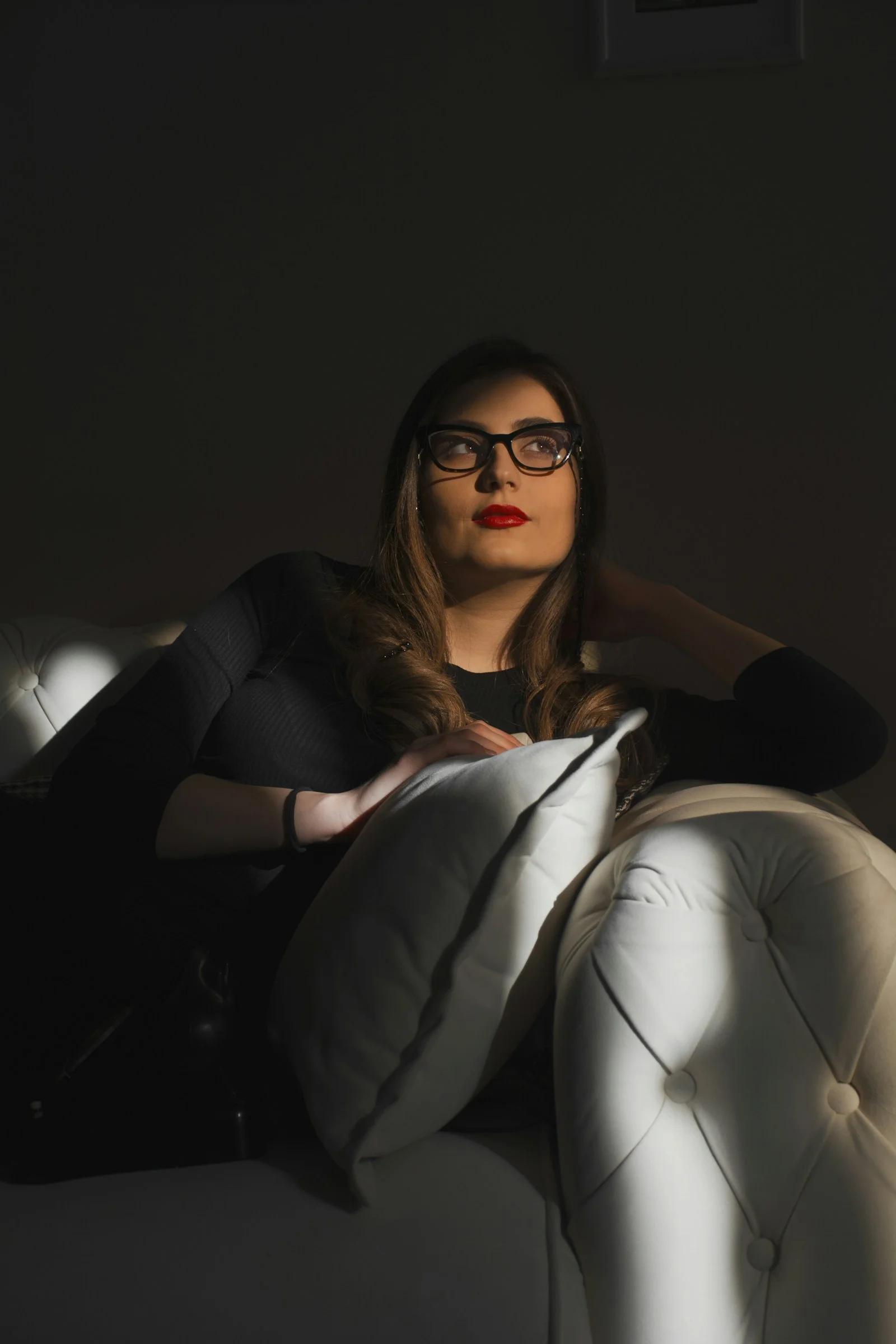 a woman sitting on top of a white couch