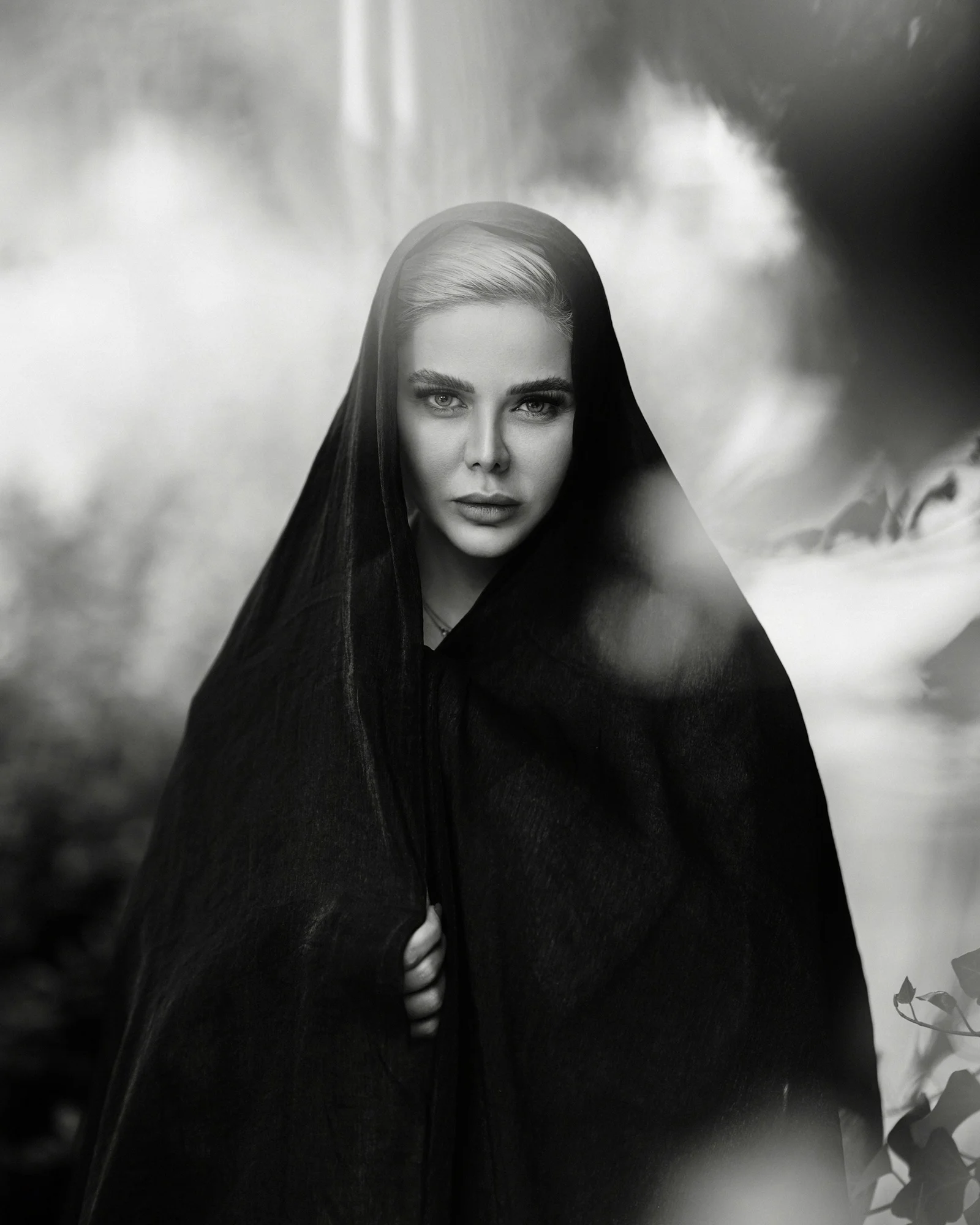 A black and white photo of a woman wrapped in a blanket