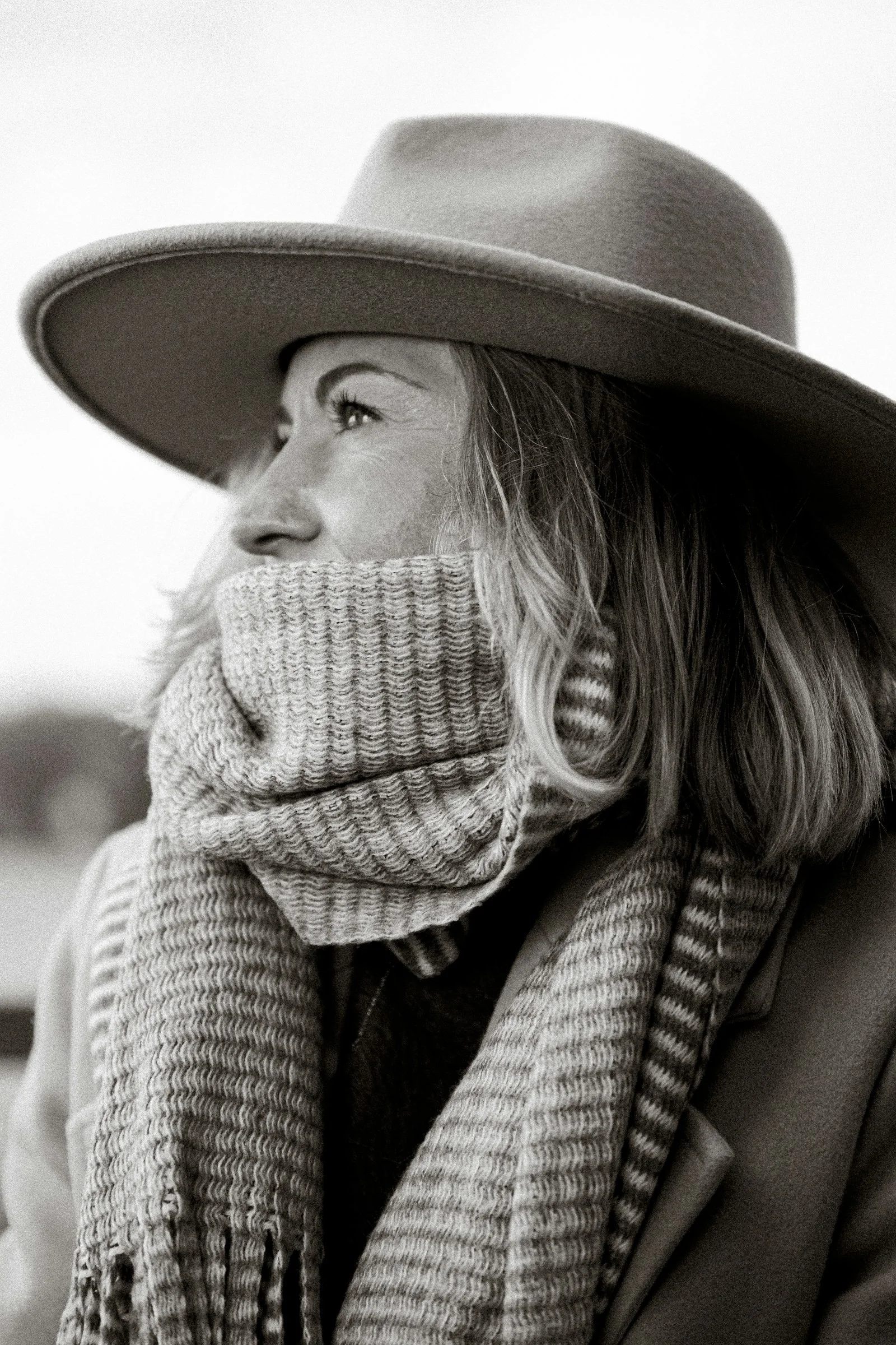 A woman wearing a hat and scarf and a scarf around her neck