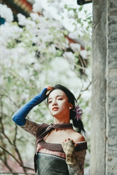 A young woman with a flower in her hair outdoors