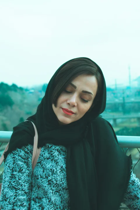 Woman wearing a black hijab and patterned sweater