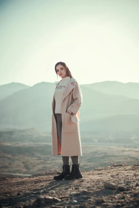 a woman standing on top of a dirt field