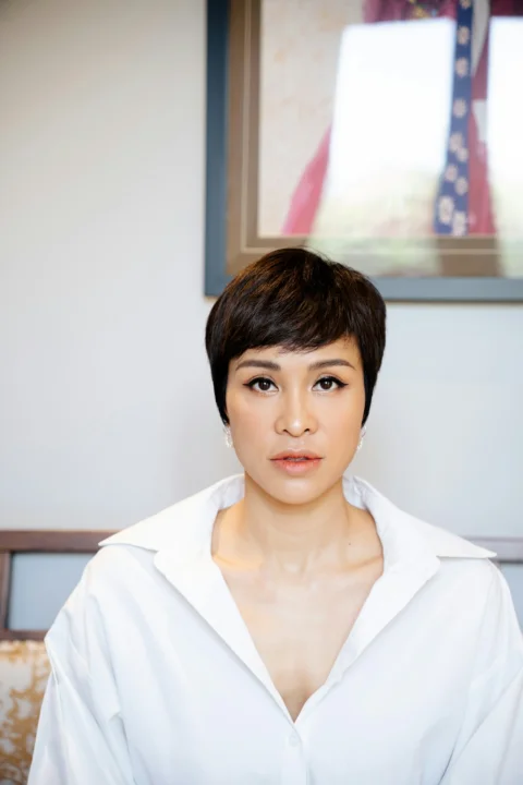 a woman with short hair wearing a white shirt