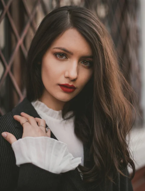 a woman with long hair wearing a sweater and a ring
