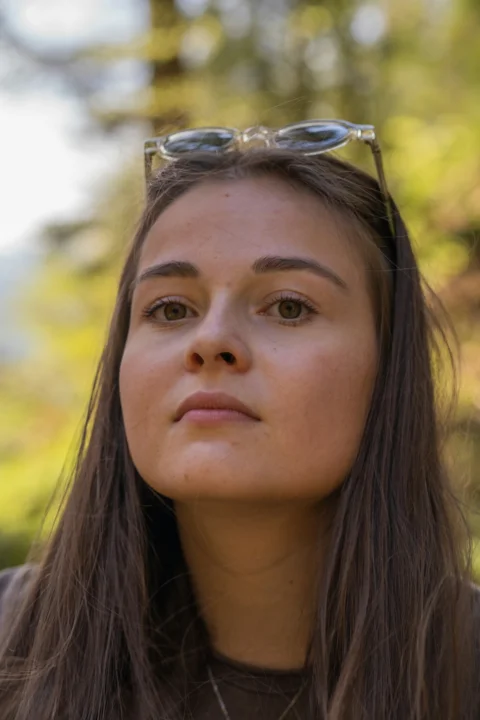 A woman wearing glasses looking off into the distance