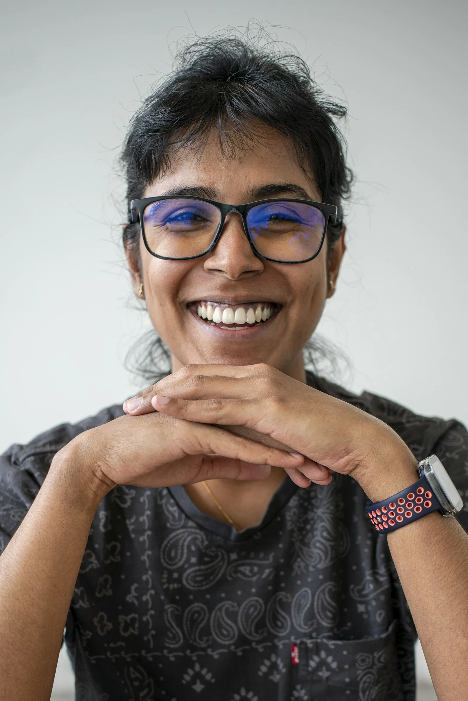 A smiling woman with glasses looks happy