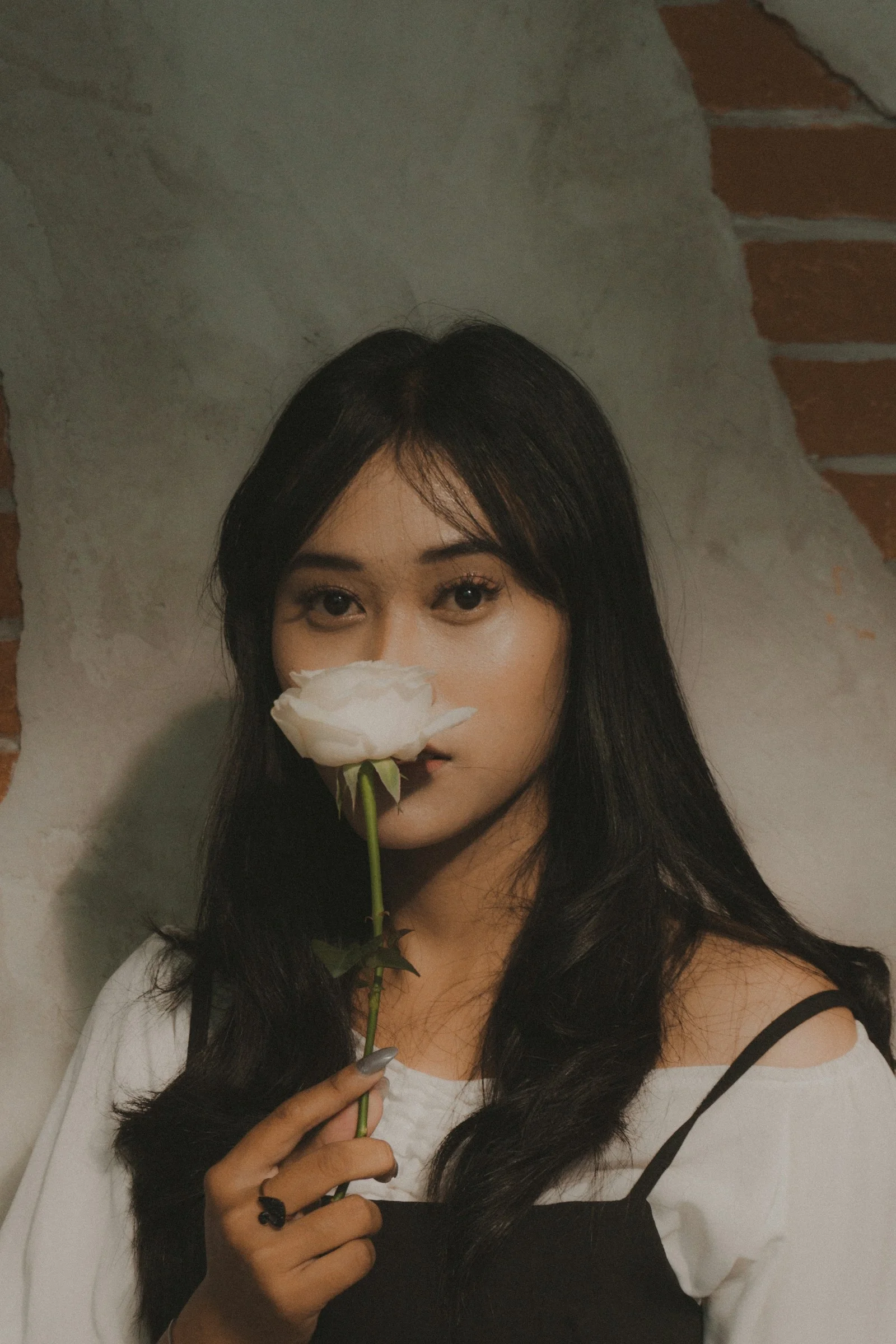 一名女性手中拿著一朵白玫瑰