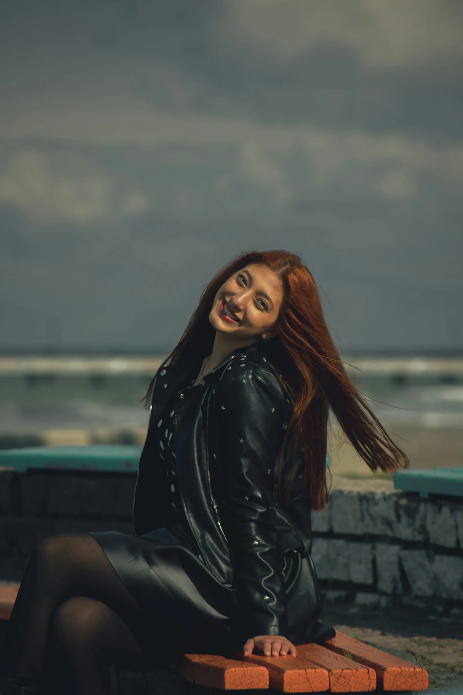 a woman with red hair sitting on a bench