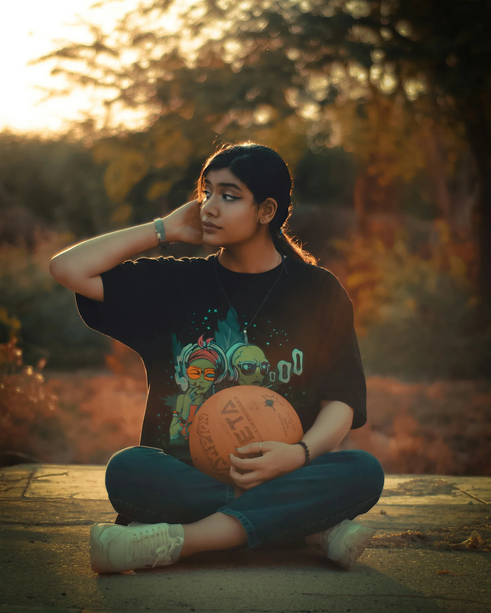 woman in black crew neck t-shirt and blue denim jeans sitting on brown wooden bench
