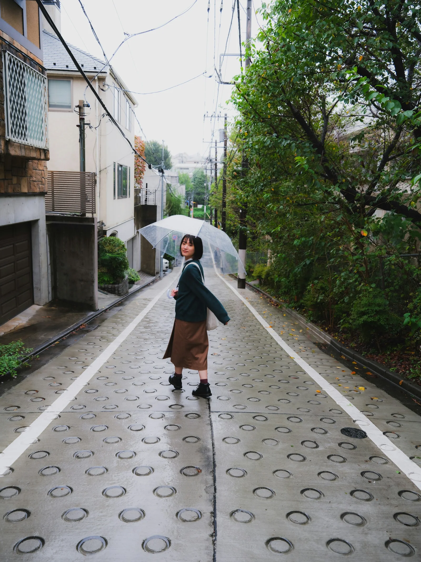 a woman walking down a street holding an umbrella