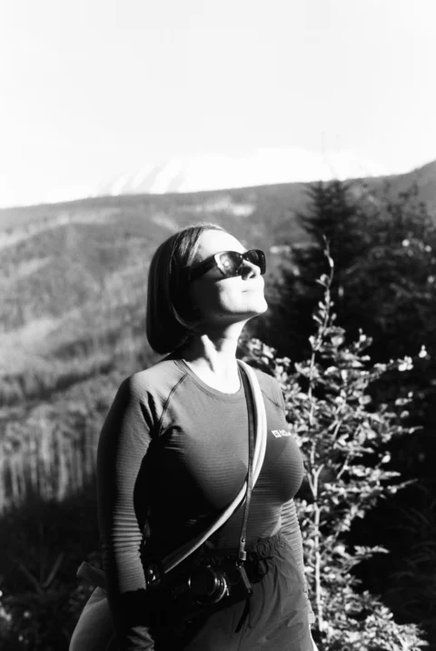 Woman in sunglasses looking up at the sun