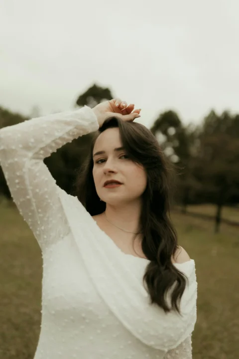 Woman with dark hair in white dress outdoors