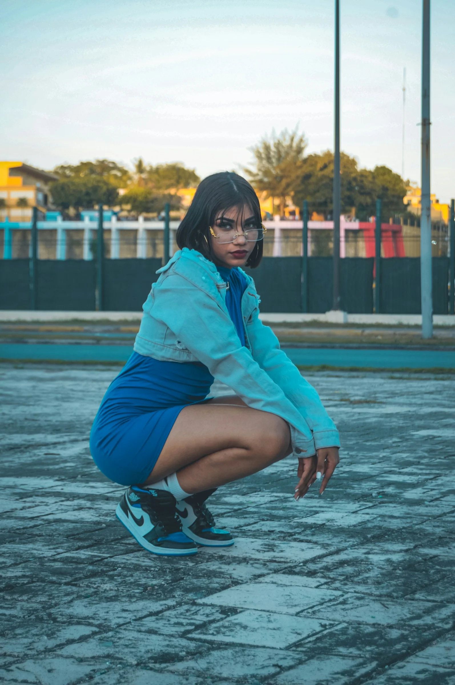 a woman squatting down in a parking lot
