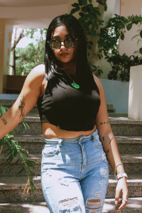 a woman wearing ripped jeans and a crop top