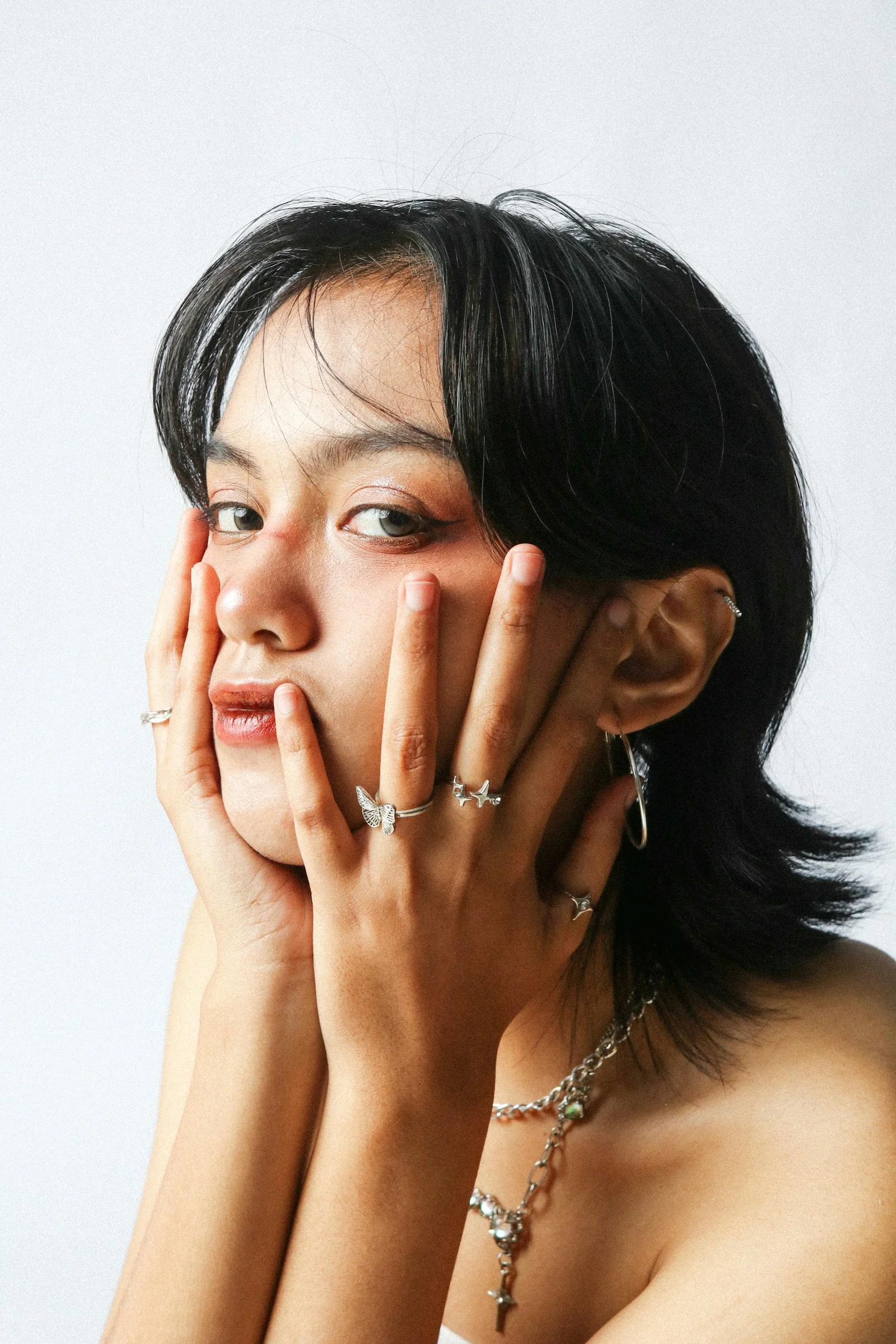 手に宝石を身につけてポーズをとる人