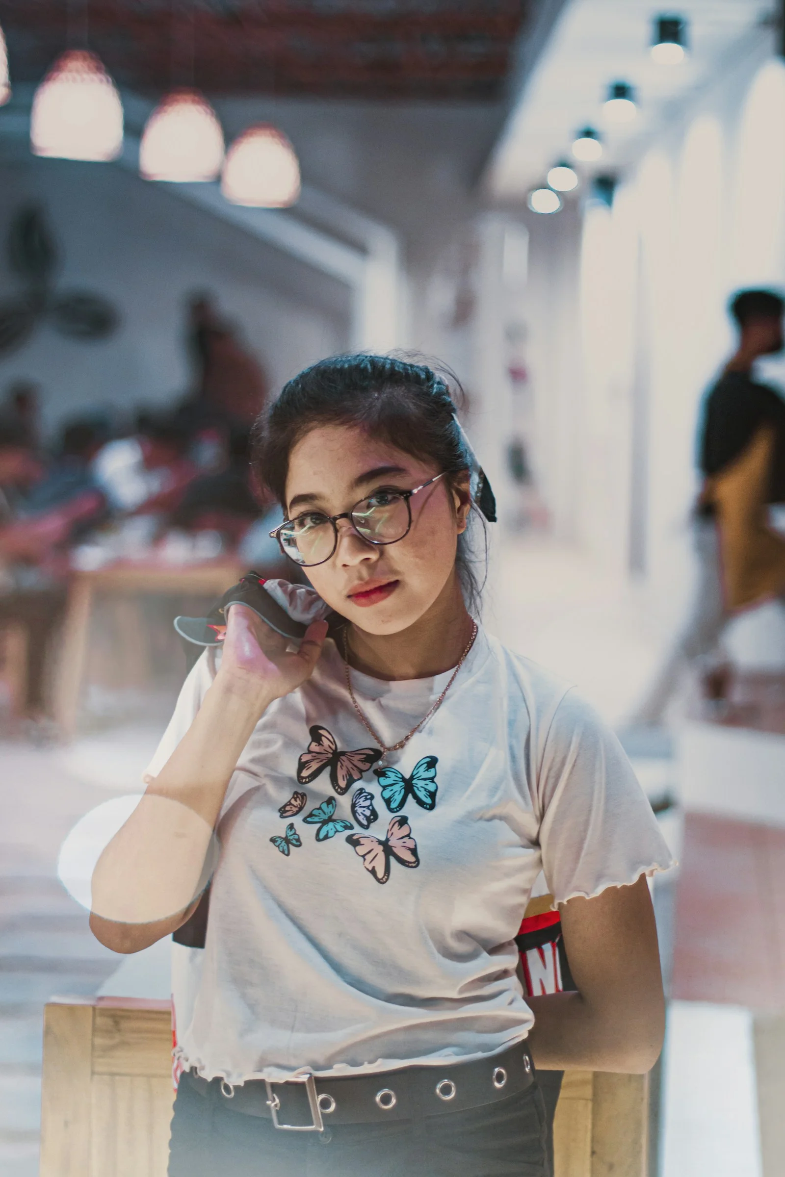 一名戴著眼鏡的女子在講手機