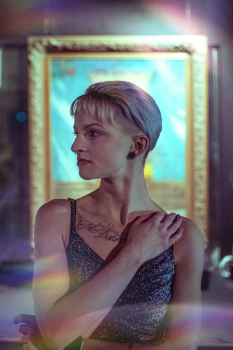 a woman standing in front of a painting