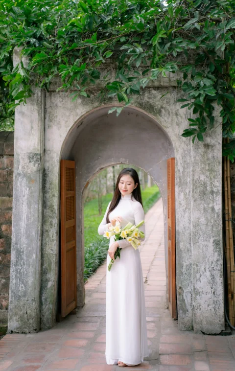 一位白衣女士站在拱门下