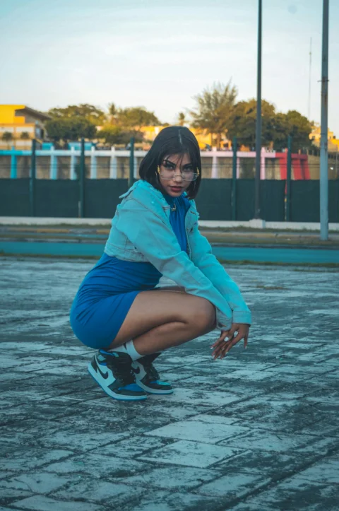 a woman squatting down in a parking lot