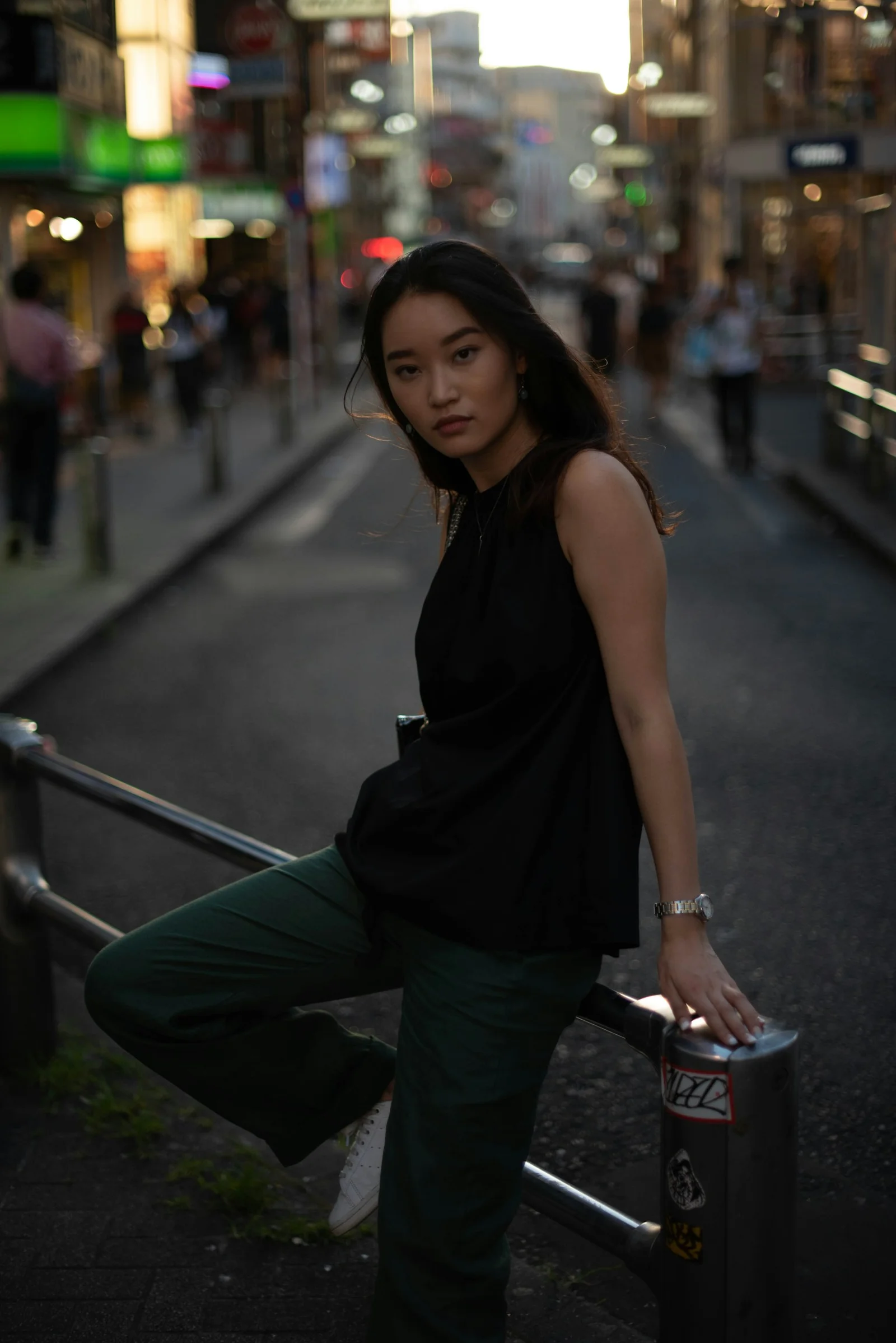 一位女子在城市街道上倚著欄杆