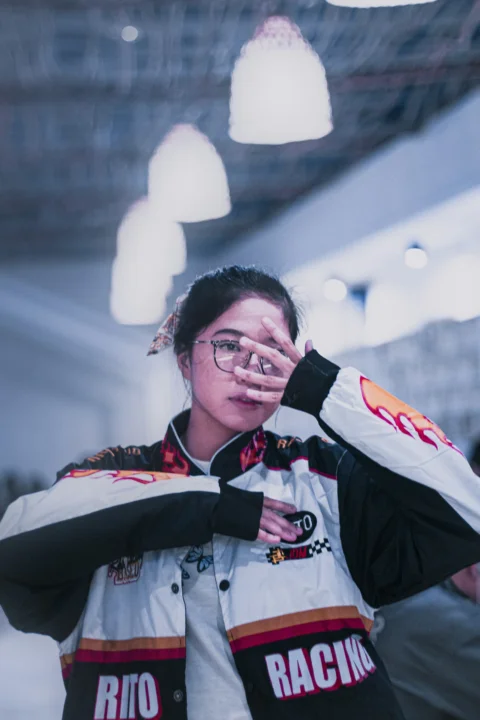 一位身穿赛车夹克的女人遮住双眼