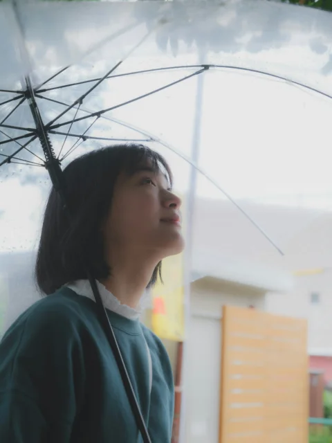 a woman standing under an umbrella in the rain