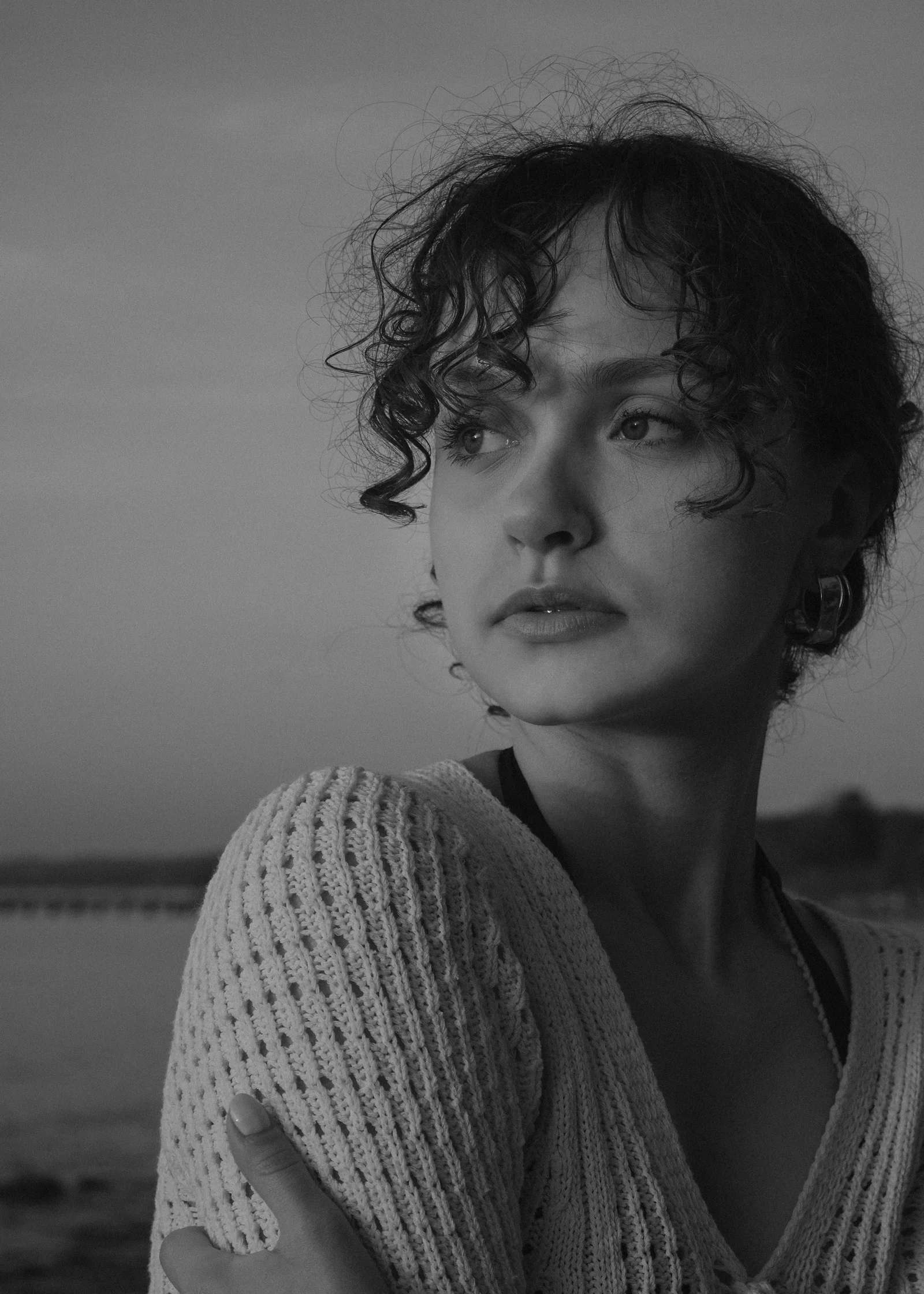 a black and white photo of a woman with curly hair