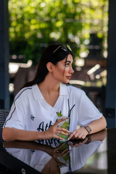 Woman holding a refreshing drink at an outdoor cafe