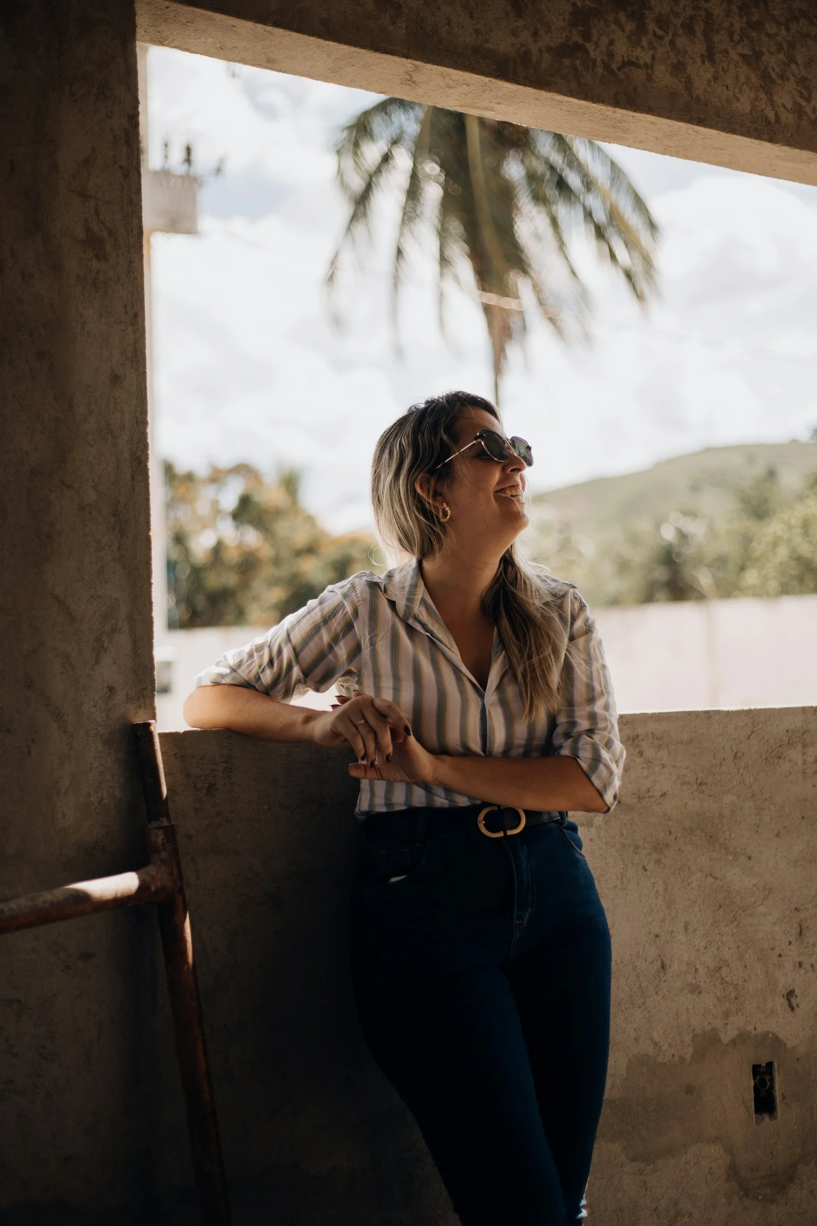 a woman leaning against a wall looking out a window
