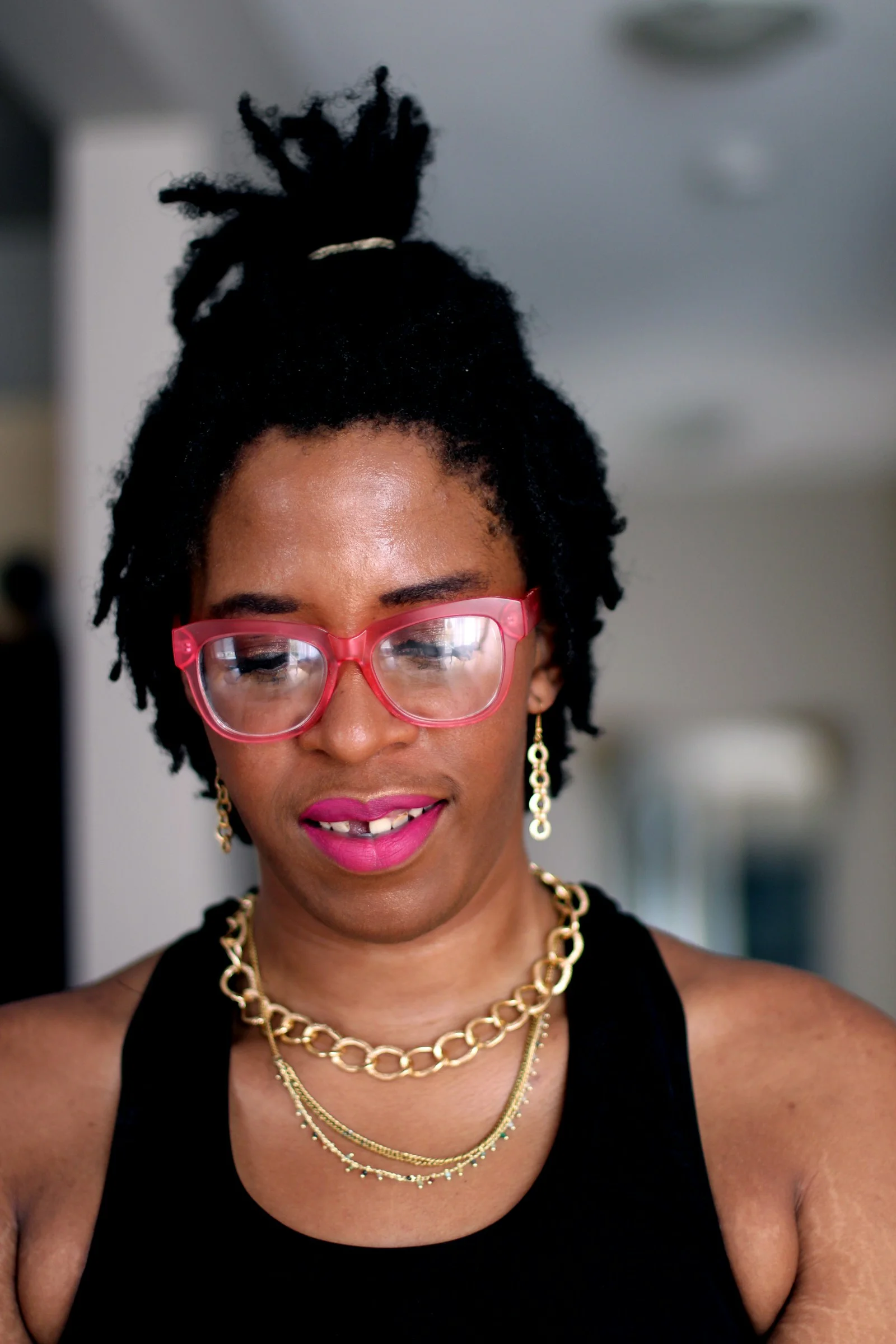 woman in black tank top wearing red framed eyeglasses
